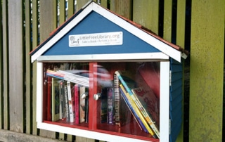Little Free Library shaped like a blue house