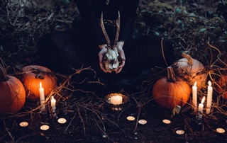 Hands holding a skull with candles