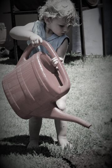 little boy with a watering can